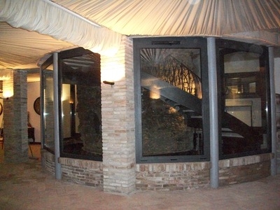 bow window su vano scale con vetrate ed infissi in alluminio verniciato scuro