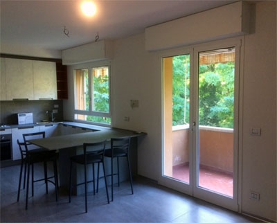 interno cucina con porta a vetri e finestra a due ante con infissi in alluminio verniciato bianco
