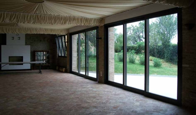 interno di salone con vetrate scorrevoli e infissi in alluminio verniciato